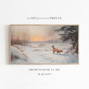 Puede incluir: Una pintura de un zorro rojo de pie en un campo nevado al atardecer. El zorro está mirando hacia la izquierda de la imagen. El cielo es de un color rosa y naranja suave. Hay árboles en el fondo. La pintura está enmarcada en un marco de madera claro.