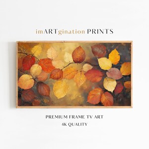 Puede incluir: Una impresión enmarcada que presenta una rama con hojas otoñales en tonos rojos, naranjas y amarillos. La obra de arte tiene una paleta de colores cálidos y está etiquetada como "imARTgination PRINTS" y "PREMIUM FRAME TV ART 4K QUALITY".