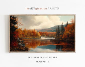 May include: A framed painting of a lake surrounded by autumn trees with a waterfall in the background. The lake is reflecting the colors of the trees and the sky. The painting is in a wooden frame.