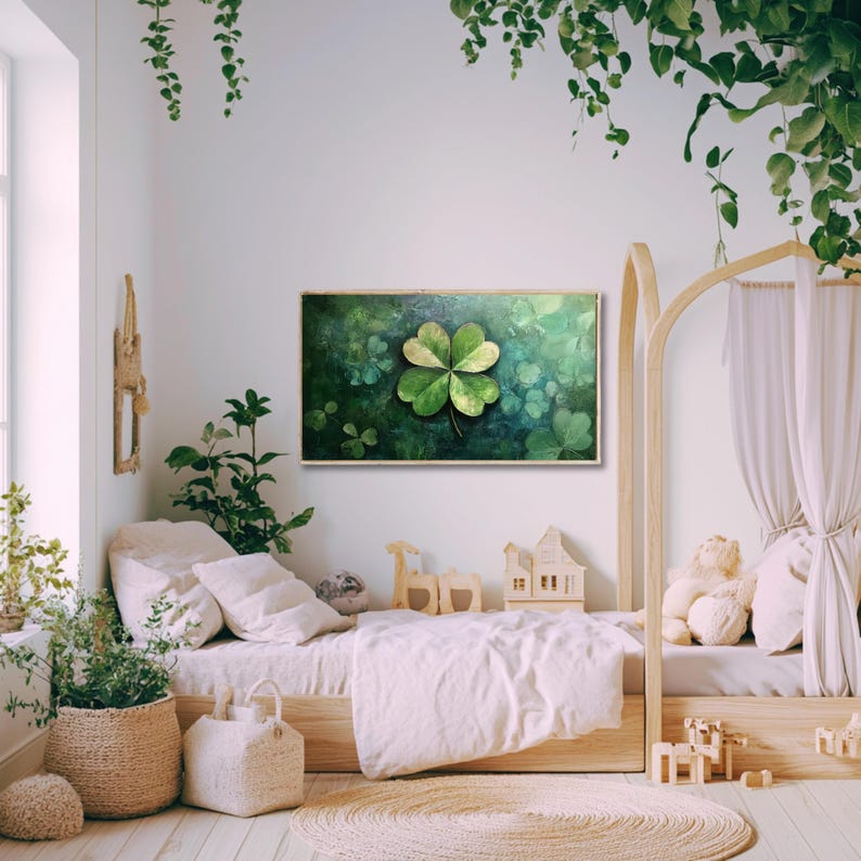 May include: A green four-leaf clover painting in a wooden frame, hanging on a white wall in a nursery with a wooden bed and green plants.