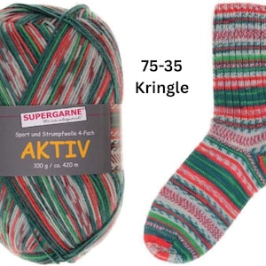 May include: A ball of Aktiv yarn and a knitted sock. The yarn is a mix of green, red, and white. The sock is a similar color pattern with the text "75-35 Kringle". The yarn label reads "SUPERGARNE AKTIV 100 g / ca. 420 m".