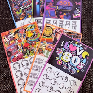 May include: A collection of six rectangular sticker sheets featuring 1980s-themed graphics. Designs include colourful illustrations of boomboxes, arcade cabinets, cassette tapes, and retro icons, alongside black and white line art of headphones and game characters.