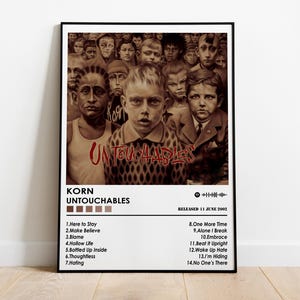 Puede incluir: Un póster enmarcado con la portada del álbum "Untouchables" de Korn. La obra de arte muestra una imagen en tonos sepia de niños. El título del álbum y el nombre de la banda son rojos. El póster incluye una lista de canciones y la fecha de lanzamiento.