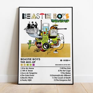 Puede incluir: Un póster colorido con una ilustración de dibujos animados de una mezcladora de música. El póster se titula "Beastie Boys The Mix-Up" y enumera la lista de canciones del álbum. El álbum fue lanzado el 24 de junio de 2000.