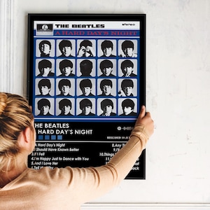 May include: A vintage record album cover featuring a black and white photo of The Beatles. The album title is "A Hard Day's Night" and the band members are arranged in a grid pattern. The album cover is framed in black.