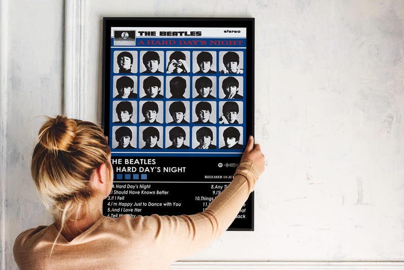 May include: A vintage record album cover featuring a black and white photo of The Beatles. The album title is "A Hard Day's Night" and the band members are arranged in a grid pattern. The album cover is framed in black.