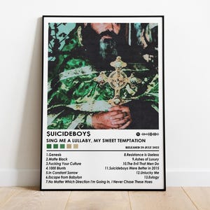 May include: A framed poster featuring the album art for "Sing Me a Lullaby, My Sweet Temptation" by $uicideboy$. The artwork depicts a person holding a cross, with the album title and tracklist displayed below. The poster is in a black frame.
