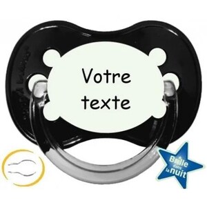 Può includere: Ciuccio nero con un ovale bianco che brilla al buio che dice "Votre texte".