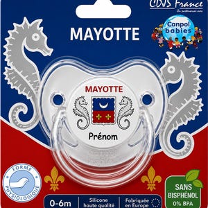 Peut inclure: Une sucette en silicone transparent pour les 0-6 mois, ornée d'un emblème central avec deux hippocampes, un croissant de lune et deux fleurs de lys. La sucette est fixée sur une carte bleue et rouge avec des motifs d'hippocampes et le texte Mayotte.