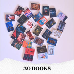 May include: An overhead shot displays a collection of 30 miniature books with various colorful covers. Titles include "Red Rising," "The Plot," and "Caraval." The text "30 BOOKS" is at the bottom.