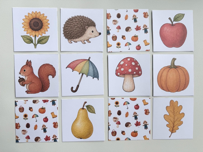 May include: A set of twelve square cards featuring autumn-themed illustrations including a sunflower, hedgehog, red apple, squirrel with an acorn, rainbow umbrella, mushroom, pumpkin, pear, oak leaf, and two patterns with various seasonal icons.