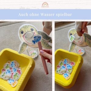 May include: A turtle-shaped cutout with a circular opening for a mouth, a yellow square bowl filled with small colorful fish-shaped tokens, and a pair of pink plastic tweezers. The text "Auch ohne Wasser spielbar" is visible at the top.