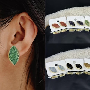 Peut inclure: Un ensemble de six paires de boucles d'oreilles avec des pierres de différentes couleurs. Les boucles d'oreilles sont en forme de larme et ont un sertissage en or. Les pierres sont vertes, rouges, violettes, noires, blanches et brunes.