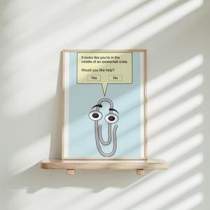 May include: A light blue poster with a white paperclip with eyes and a speech bubble. The speech bubble says "It looks like you're in the middle of an existential crisis. Would you like help?" with two buttons that say "Yes" and "No".
