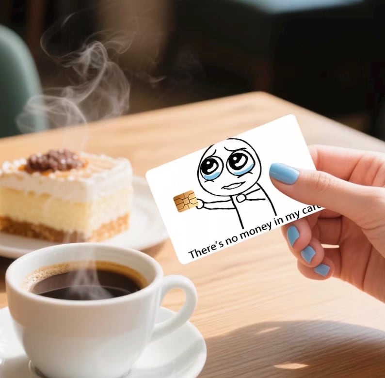 K&ouml;nnte beinhalten: Eine wei&szlig;e rechteckige Kreditkarte mit einer schwarz-wei&szlig;en Strichzeichnung einer weinenden Figur, die einen goldenen Chip h&auml;lt. Der Text "There's no money in my card" ist in Schwarz auf der Unterseite der Karte aufgedruckt.