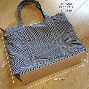 May include: A striped tote bag with a light brown base and handles. The bag is 20 inches wide, 15.5 inches tall, and 5 inches deep. The bag has a blue and white striped pattern and the word "DIMENSIONS" is at the top.