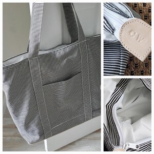May include: A large tote bag with black and white horizontal stripes. The bag has a front pocket and a white interior. The zipper pull is a light tan leather with the initials "CW" embossed on it. The bag has two black and white striped handles.