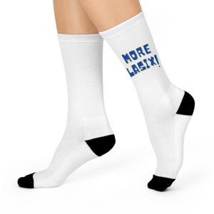 May include: White socks with black heels and toes. The text "MORE LASIX!" is printed in blue on the side of the sock. The socks are mid-calf length.
