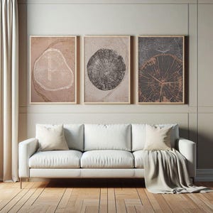 Puede incluir: Tres impresiones de arte abstracto enmarcadas con una paleta de colores neutres. Cada impresión presenta un diseño circular con un patrón de veta de madera en tonos marrones y grises.