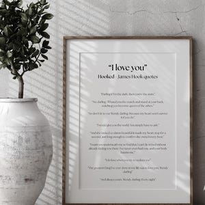 Puede incluir: Una impresi&oacute;n enmarcada con la cita "I love you" y citas de James Hook. La impresi&oacute;n tiene un fondo blanco con texto negro y est&aacute; en un marco de madera. A la izquierda hay una planta decorativa en un jarr&oacute;n blanco.