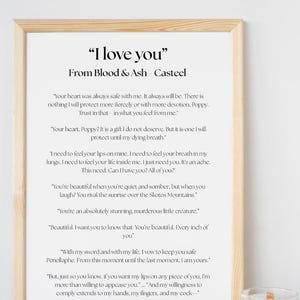 May include: A framed print with the text "I love you" and romantic quotes from "Blood & Ash" by Casteel. The print has a light wood frame and is displayed on a white surface.