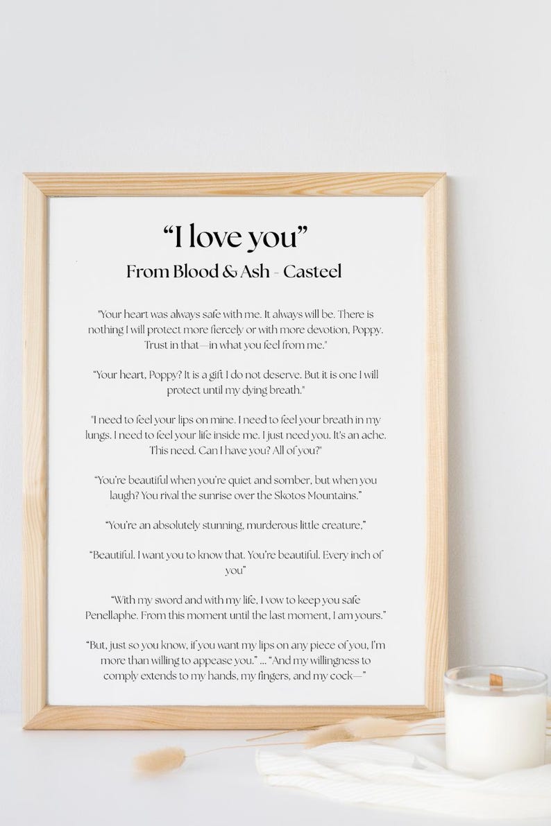 May include: A framed print with the text "I love you" and romantic quotes from "Blood & Ash" by Casteel. The print has a light wood frame and is displayed on a white surface.