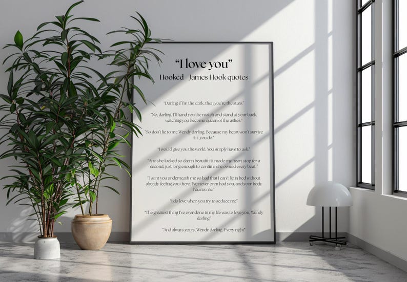 Puede incluir: Una impresi&oacute;n en blanco y negro enmarcada con el texto "I love you" y citas de James Hook. La impresi&oacute;n se muestra en una pared junto a plantas en macetas y una l&aacute;mpara moderna.