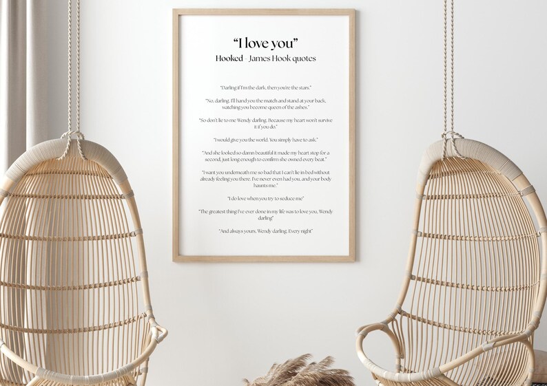 Puede incluir: Una impresi&oacute;n enmarcada con el texto "I love you" y citas de James Hook. La impresi&oacute;n est&aacute; en un marco de madera clara y cuelga de una pared blanca. Dos sillas colgantes de mimbre est&aacute;n en primer plano.