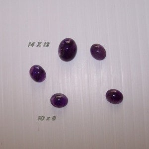 Puede incluir: Cinco cabujones de amatista púrpura de diferentes tamaños. El cabujón más grande mide 14 x 12, y el más pequeño mide 19 x 8.