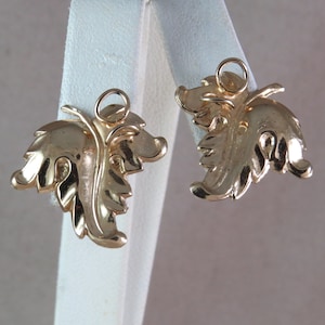 Puede incluir: Un par de pendientes de hoja de oro con cierre de bucle simple.