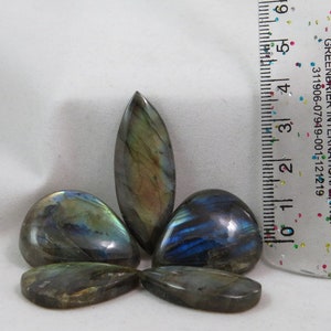 Puede incluir: Cinco cabujones de labradorita iridiscente en varios tonos de azul, verde y dorado. Las piedras tienen forma de lágrima y miden aproximadamente 2,5 cm de largo.