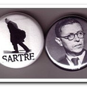 May include: Four round white button pins with black text and images. The first pin features a black and white image of Jean-Paul Sartre with the text "J.P. Sartre". The second pin features a black and white image of a man walking with the text "Sartre". The third pin features a black and white image of a man with the text "Hell is other people". The fourth pin features the text "Hell is other people".