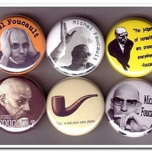 以下が含まれることがあります： 哲学者ミシェル・フーコーの画像と引用文が描かれた丸いボタンが6つ。ボタンは黄色、オレンジ、白、茶色です。