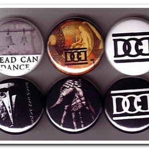 Peut inclure: Six boutons ronds avec des motifs différents. Un bouton présente une image en noir et blanc d'un visage avec un seul œil. Un autre bouton présente une image en noir et blanc d'une main avec les lettres "DCI" en blanc. Un autre bouton présente une image en noir et blanc des lettres "DCI" en blanc. Un autre bouton présente une image en noir et blanc des lettres "DCI" en blanc. Un autre bouton présente une image en noir et blanc des lettres "DCI" en blanc. Un autre bouton présente une image en noir et blanc des lettres "DCI" en blanc. Le dernier bouton présente une image en noir et blanc des lettres "DCI" en blanc.