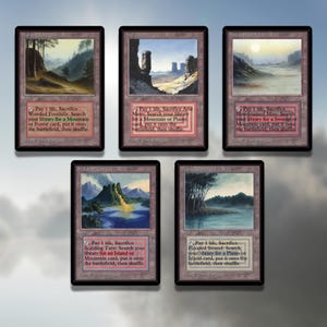 May include: Five Magic: The Gathering cards with illustrations of landscapes. Each card has a text box with the card's name, mana cost, type, and abilities. The cards are: Wooded Foothills, Arid Mesa, Bloodstained Mire, Scalding Tarn, and Flooded Strand.