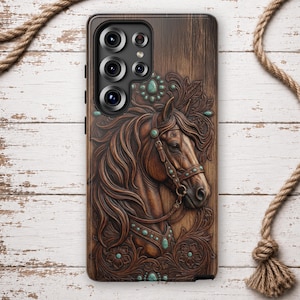 May include: A rectangular phone case featuring a dark brown wood grain texture with a relief carving of a horse head. The horse wears a bridle adorned with small turquoise-coloured stones. Additional turquoise accents are embedded in the floral carvings.