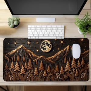 May include: A rectangular desk mat featuring a dark brown and black relief-style landscape of mountains and pine trees under a starry night sky with a large, textured full moon. A white computer mouse rests on the right side of the mat.