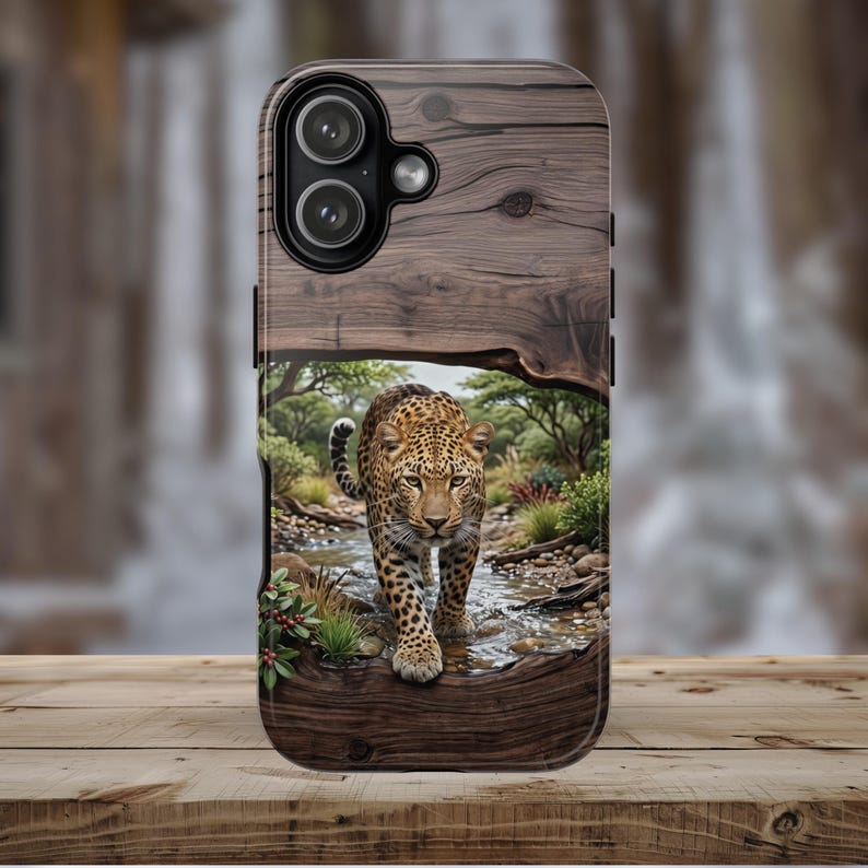 May include: A rectangular phone case featuring a wood grain texture on the top and bottom sections. The center displays a detailed image of a leopard walking through a shallow stream in a natural landscape with green trees and bushes.