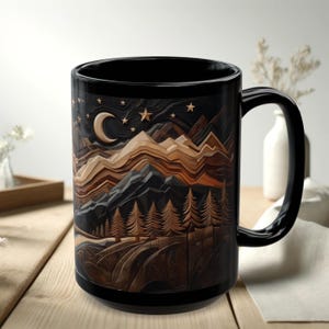 May include: Black ceramic mug featuring a detailed mountain landscape design with a crescent moon and stars. The design incorporates shades of brown, tan, and black, creating a layered, textured effect. The mug has a large handle.