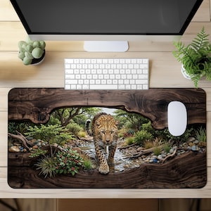 Puede incluir: Una alfombrilla de escritorio rectangular con una impresión de alta resolución de un leopardo caminando por un arroyo poco profundo en un bosque. El diseño está enmarcado por un borde de grano de madera oscuro y texturizado que imita un tronco.