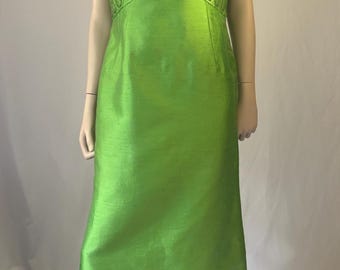 May include: A sleeveless lime green floor-length dress featuring a high neckline and a fitted bodice. The upper chest and collar are embellished with intricate gold-toned floral embroidery and sequins, while the skirt remains plain and smooth.