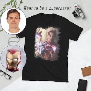 May include: Black t-shirt with a graphic of Iron Man in a superhero pose. The text "Want to be a superhero?" is printed above the graphic.