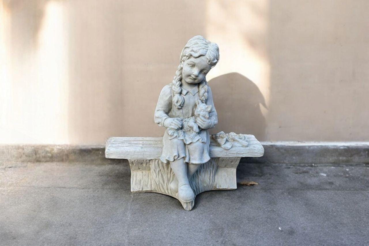 Girl sitting on bench Concrete girl with kitten Stone baby girl Realistic girl with cat Outdoor statue Garden bench