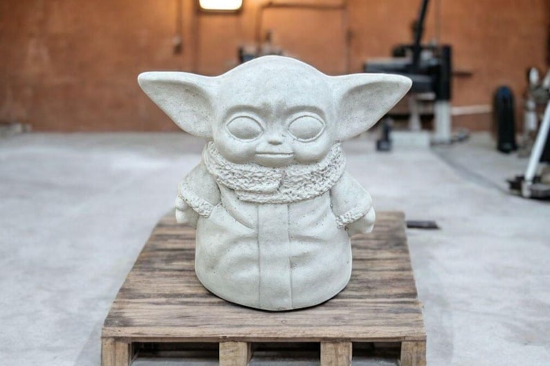 K&ouml;nnte beinhalten: Eine wei&szlig;e Keramikstatue eines fiktiven Charakters mit gro&szlig;en Ohren und einem Pelzkragen. Die Statue steht auf einer Holzplattform.