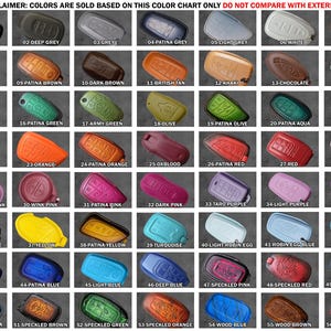 May include: A color chart displaying 56 individual car key fob covers in various shades and finishes, labeled 01 through 56. The grid includes solid colors, patina finishes, and speckled patterns, with a disclaimer at the top in red text.
