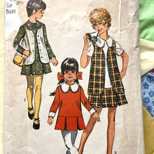 May include: Vintage Simplicity sewing pattern featuring illustrations of children's dresses. The pattern includes a size 10 with a 28.5-inch bust. The cover art showcases three children in different dress designs, with a retro aesthetic.