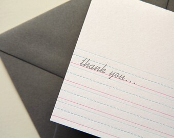 May include: A white card with blue and red lines, resembling lined paper. The card has the handwritten message "thank you..." on it.