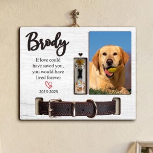 May include: A wooden pet memorial frame with a photo of a yellow Labrador holding a ball. The frame includes the name "Brody", a heartfelt message, and a space for a dog collar. A small glass bottle with a charm is also included.