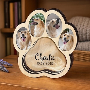 May include: A wooden paw-shaped photo frame with four oval openings for pictures of a golden retriever. The frame has a dark brown border and includes the name "Charlie" and the date "19.12.2015" in the center.