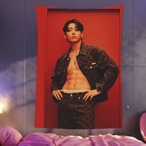 Puede incluir: Un tapiz con una persona con una chaqueta estampada y pantalones a juego, con ropa interior Calvin Klein. El fondo es un panel rojo contra una pared gris, con una cama y una lámpara en primer plano. El tema es la moda.